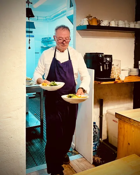 Philippe sortant de la cuisine avec deux assiettes